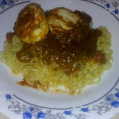 A picture of Egg curry with noodles.