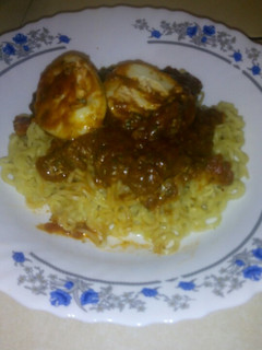 A picture of Egg curry with noodles.