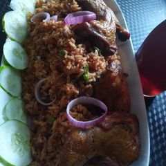 A picture of Birthday jollof with grilled chicken laps.