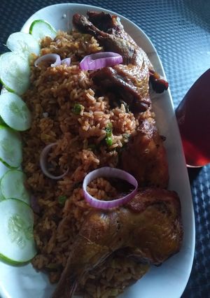 A picture of Birthday jollof with grilled chicken laps.