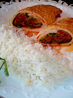 Una foto de Rulos de pechuga de pavo rellenos con guarnición de arroz