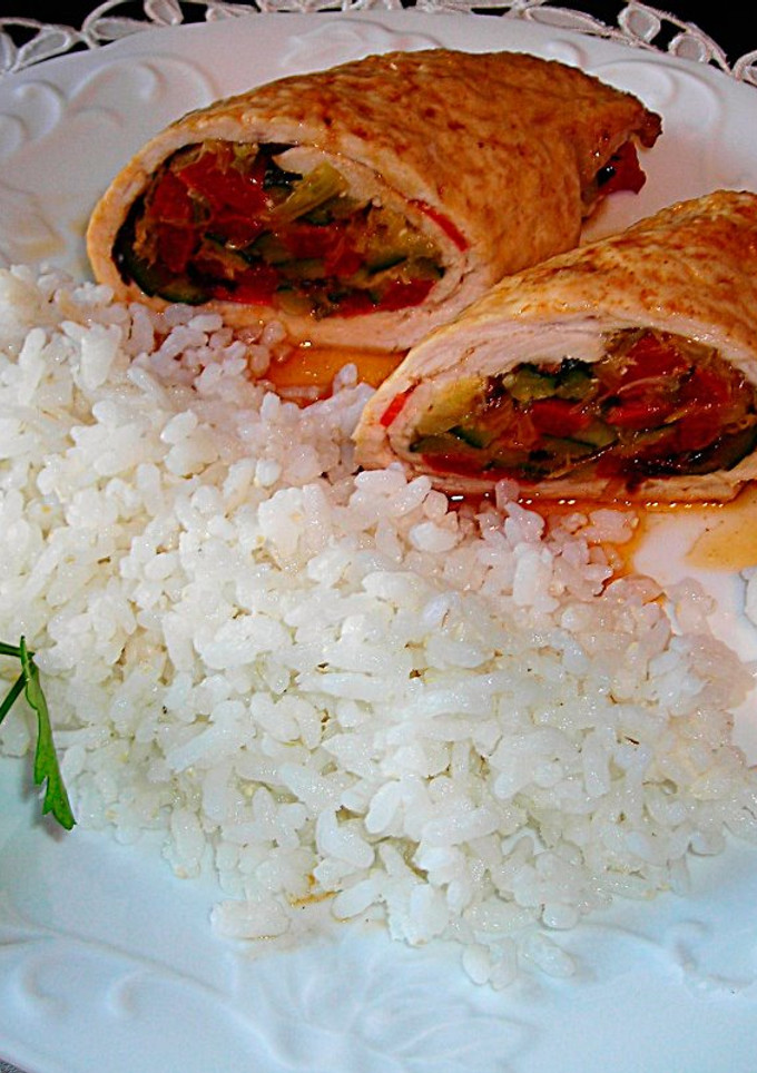 Una foto de Rulos de pechuga de pavo rellenos con guarnición de arroz
