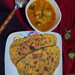 A picture of Triangle methi khasta paratha with aloo tamater sabji.