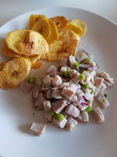 Una foto de Ceviche con limón, cebolla roja y pimiento verde