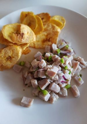 Una foto de Ceviche con limón, cebolla roja y pimiento verde