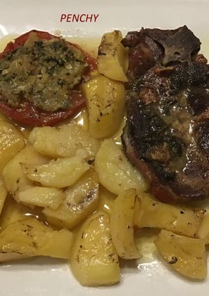 Una foto de Chuletas de cabeza asadas con tomates rellenos al ajo