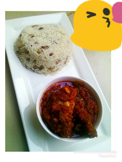 A picture of Rice and beans with chicken stew.