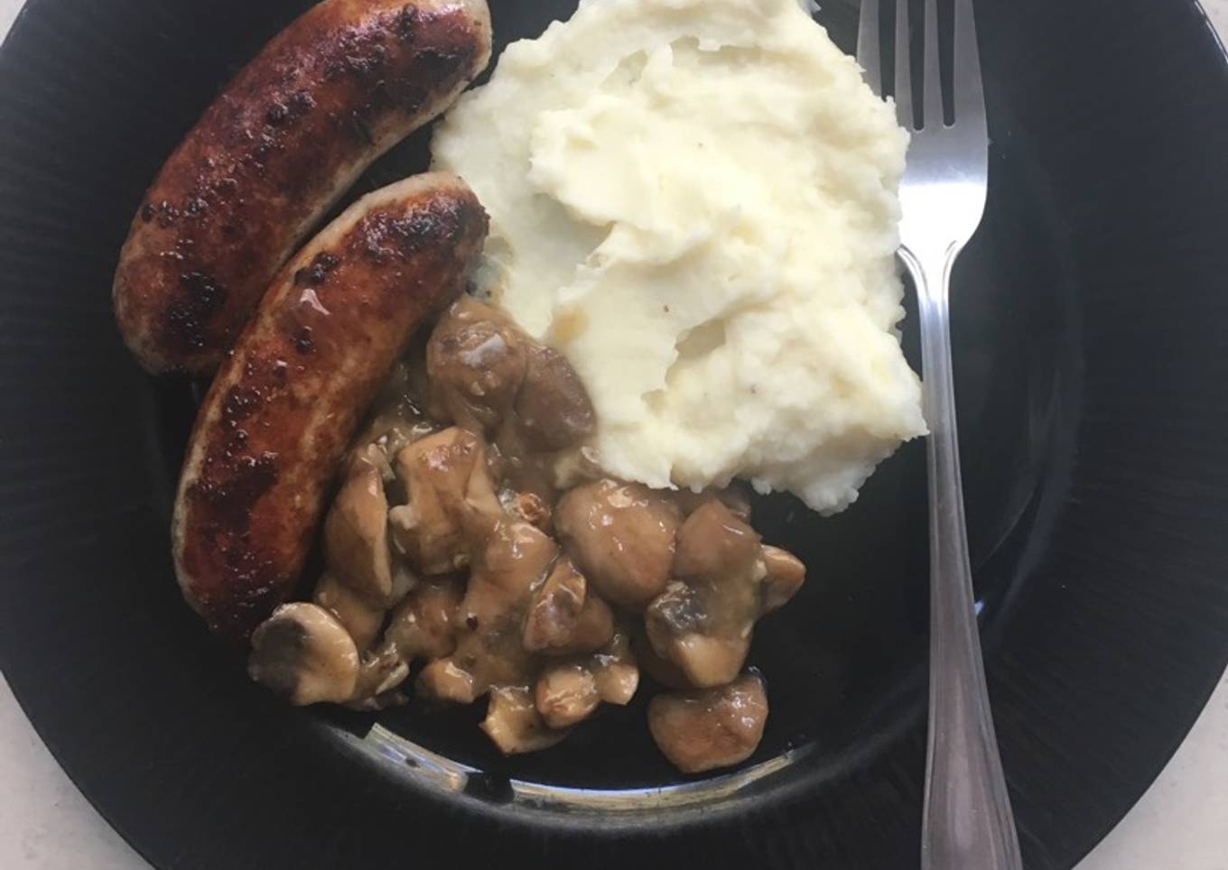 Pork bangers with creamy mashed potatoes and mushroom sauce