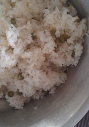 A picture of Rice with plenty of peas.