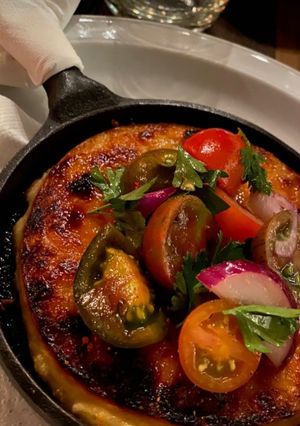 Una foto de Provolone con rúcula, tomatines, cebolla roja grillados con miel