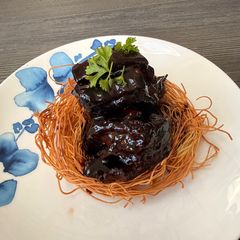 A picture of Braised Beef Short Ribs with Shiraz & Crispy Egg Noodle Nest.