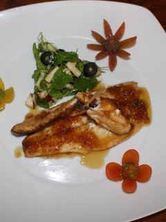 Una foto de Filete de Lubina a la plancha, con salsa de limón, lima y miel, acompañado de ensalada de rúcula, manzana roja y aceitunas negras