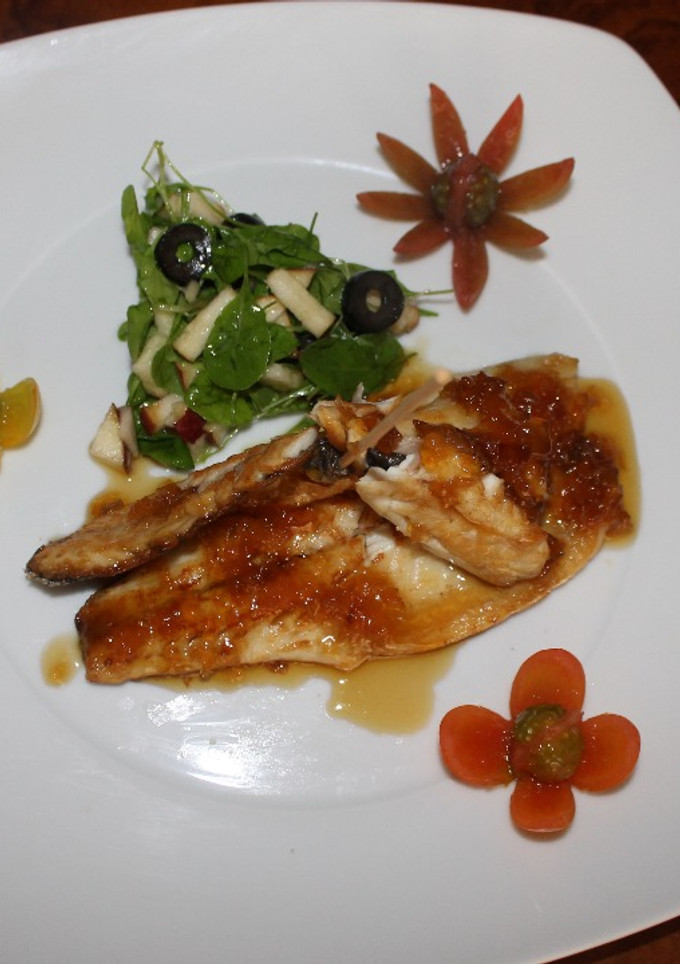 Una foto de Filete de Lubina a la plancha, con salsa de limón, lima y miel, acompañado de ensalada de rúcula, manzana roja y aceitunas negras