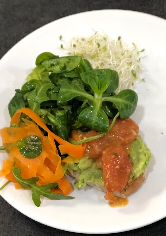 Una foto de Tosta de aguacate con tomate confitado y paté de aceitunas