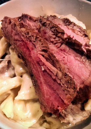 A picture of Flank Steak over Tortellini in Parmesan Cream sauce.