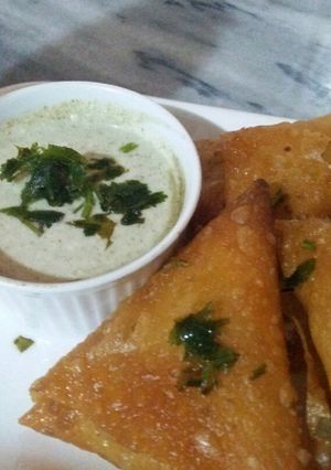 A picture of Homemade veg samosas with hari chutney.