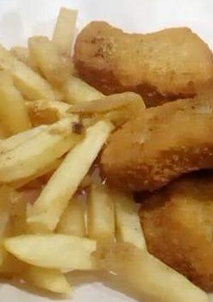 A picture of Chicken nuggets with french fries.