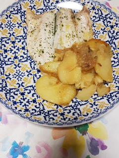 Una foto de Lubina al horno con patatas y cebolla