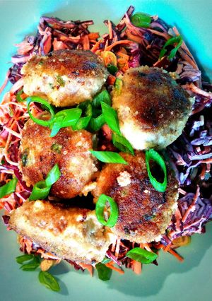 A picture of Thai-inspired pork meatballs with sesame-soy shredded vegetables.