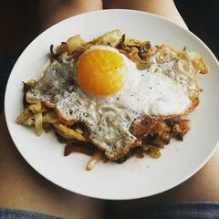 A picture of Egg topped southern fried cabbage.