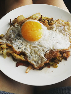 A picture of Egg topped southern fried cabbage.