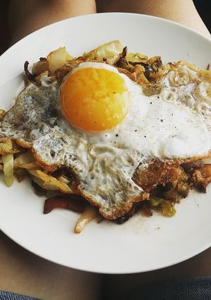 A picture of Egg topped southern fried cabbage.