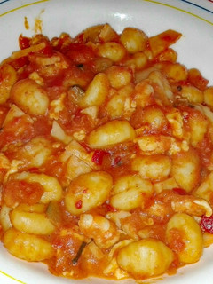 Una foto de Ñoquis con pisto, gambas y queso fresco