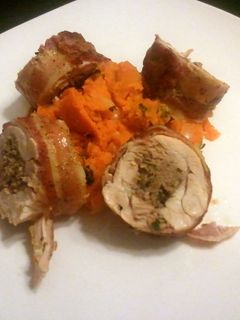 A picture of Bacon wrapped sausage stuffed chicken with sweet potatoes.
