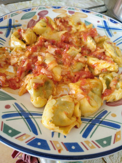 Una foto de Tortellini de espinacas con salsa de mantequilla y tomate
