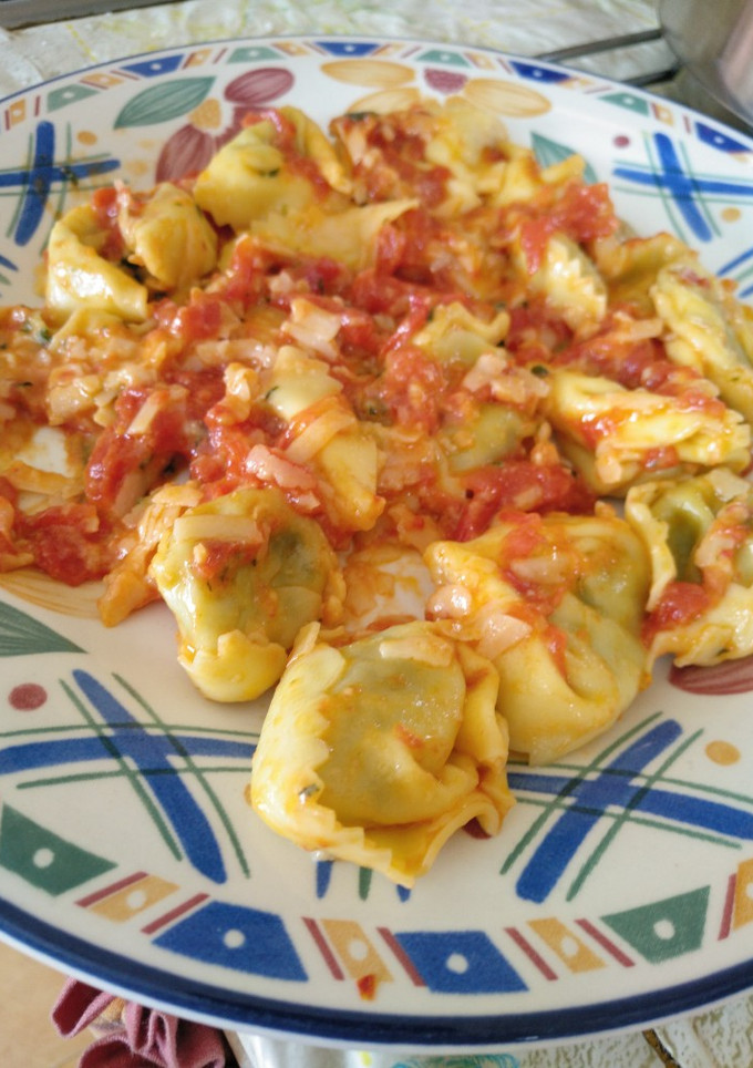 Una foto de Tortellini de espinacas con salsa de mantequilla y tomate