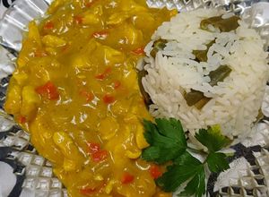 Una foto de Pollo al curry con timbal de arroz con chauchas