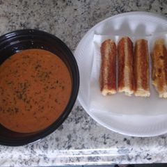A picture of Homemade tomato basil soup with grilled cheese roll ups.