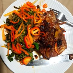 A picture of Honeyed Pork chop on Kales bed.