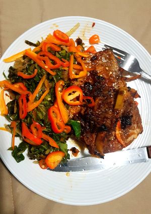 A picture of Honeyed Pork chop on Kales bed.