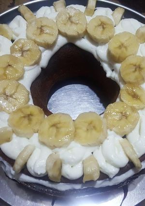 صورة لوصفة كيكة مزينه بالكريمه والموز ومحشيه بالكريمه