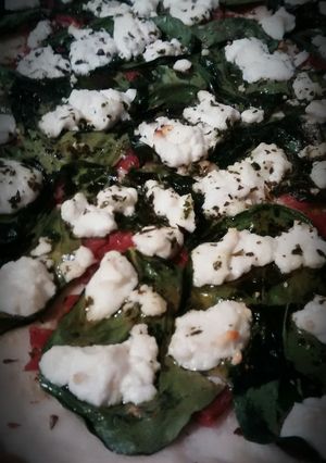 A picture of Spinach and goat cheese pizza.