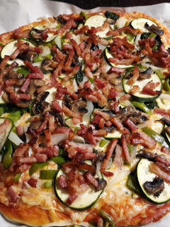 Una foto de Pizza de bacon, calabacín y más