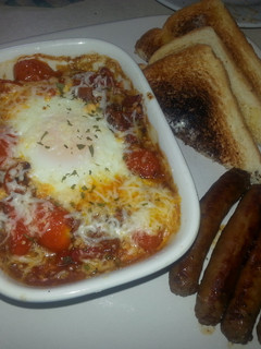 A picture of Shakshuka:eggs in fiery tomatoes.