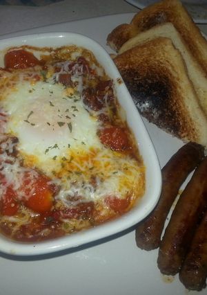 A picture of Shakshuka:eggs in fiery tomatoes.