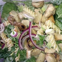 A picture of chicken & mushroom pasta with baby spinach.