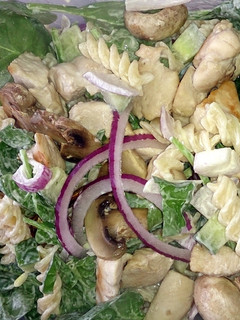 A picture of chicken & mushroom pasta with baby spinach.