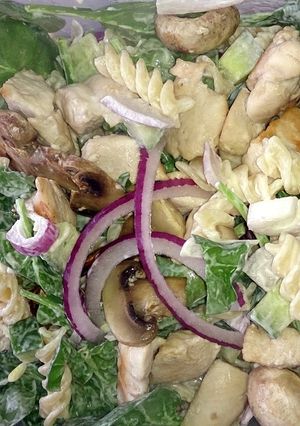 A picture of chicken & mushroom pasta with baby spinach.