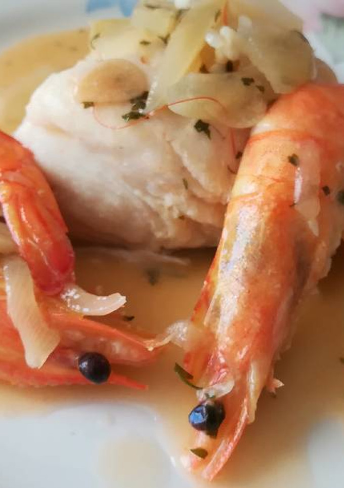 Una foto de Lomos de merluza en salsa con langostinos