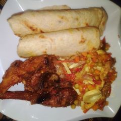 A picture of Flat bread, fried chicken with side vegetable sauce.
