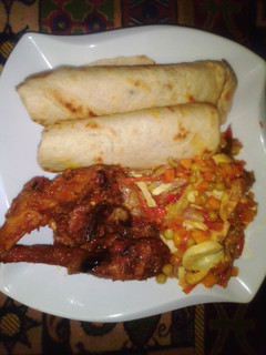 A picture of Flat bread, fried chicken with side vegetable sauce.
