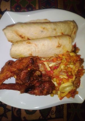 A picture of Flat bread, fried chicken with side vegetable sauce.