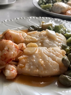 Una foto de Bacalao con gambones al ajillo y habas con ajos tiernos