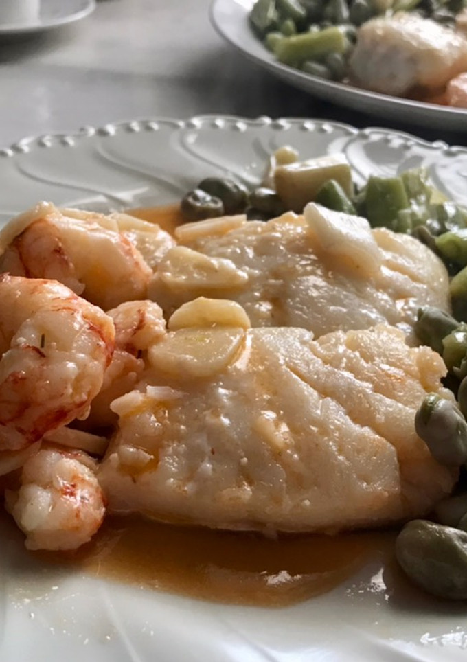 Una foto de Bacalao con gambones al ajillo y habas con ajos tiernos