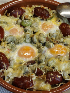 Una foto de Habas frescas horneadas con choricitos rojos y huevos