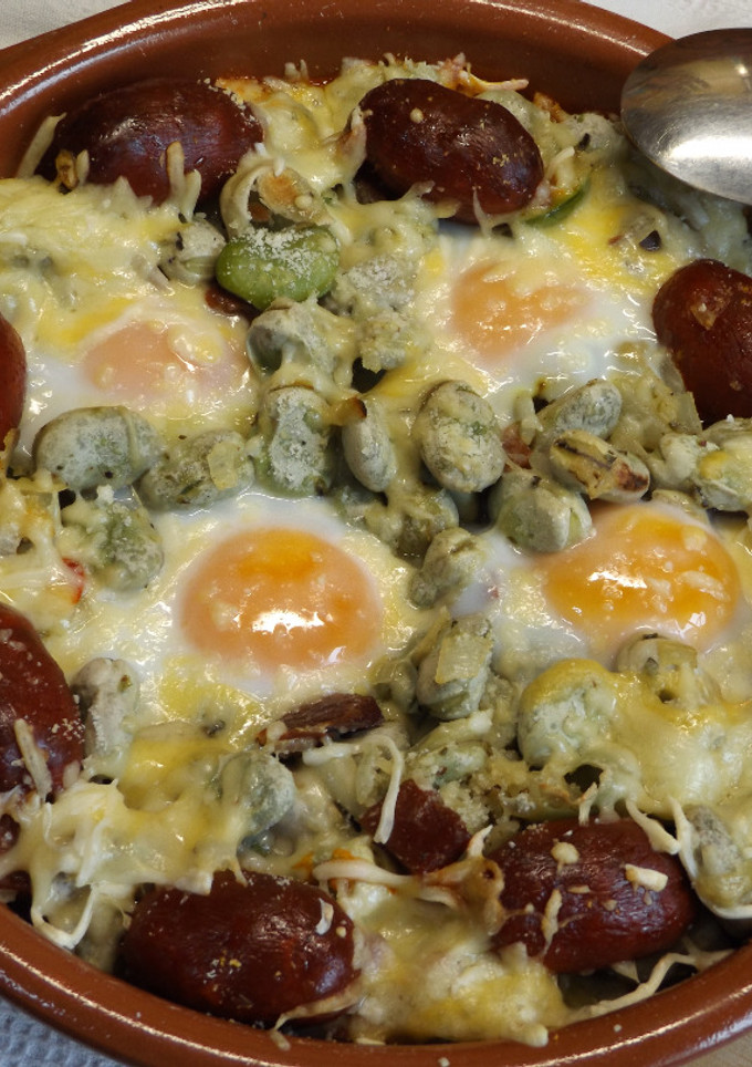 Una foto de Habas frescas horneadas con choricitos rojos y huevos
